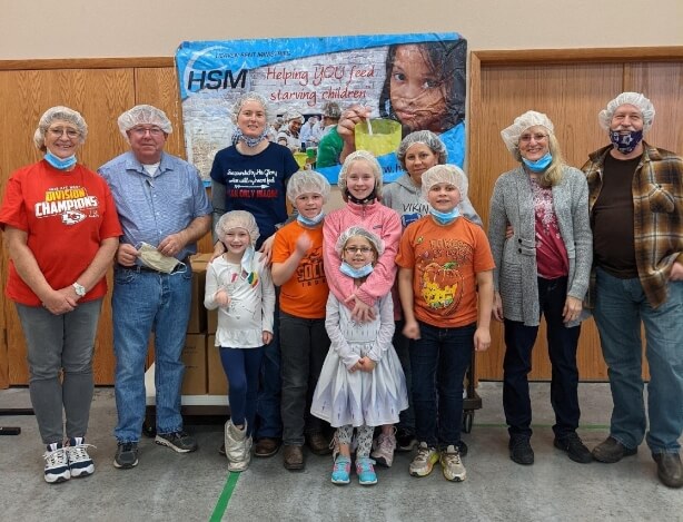 Group of volunteers wearing facemasks and hair nets