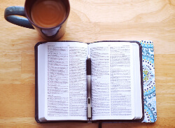 Open Bible with a pen and cup of coffee