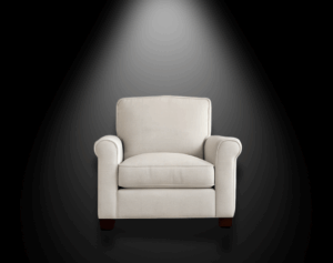 White chair against a black background. A faint light is illuminating the chair from above.